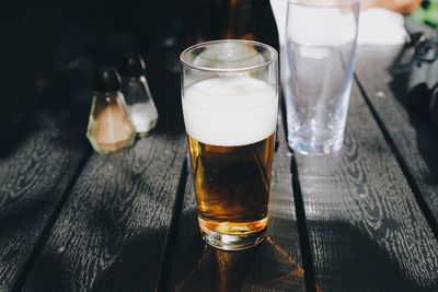 High angle view of beer glass on wooden table at restaurant