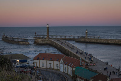 Pier over sea against sky during sunset