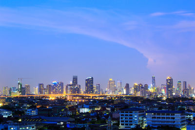 Illuminated buildings in city against sky