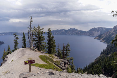 Scenic view of sea against sky, crater lake national park, danger signs