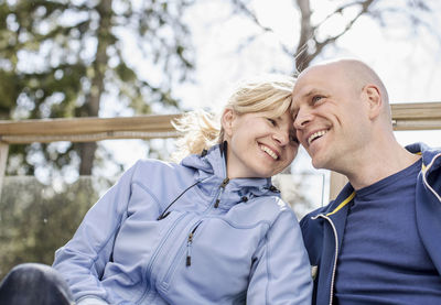 Low angle view of happy mature couple sitting outdoors