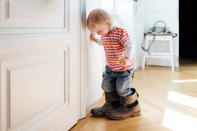 Boy wearing shoes on floor at home