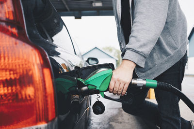 Midsection of man photographing car