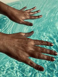 Cropped hands of woman in swimming pool