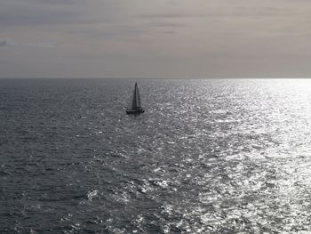Sailboat sailing on sea against sky