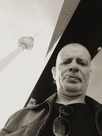 Low angle portrait of young man against sky