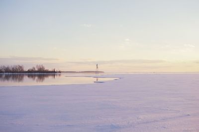 Scenic view of frozen lake against sky during sunset