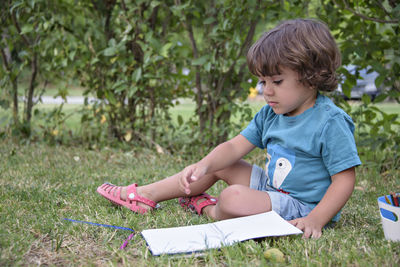 Portrait of cute girl sitting on field
