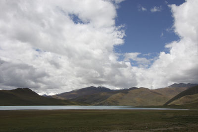 Scenic view of land and mountains against sky