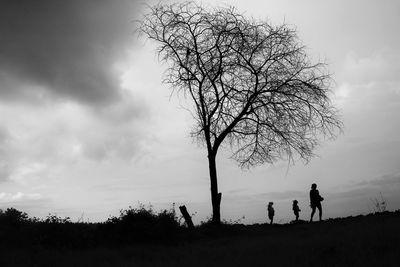 Silhouette people on field against sky