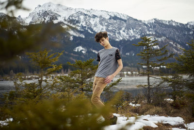 Full length of man standing on lake against mountain