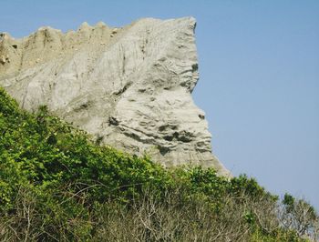 Low angle view of rocks against clear sky