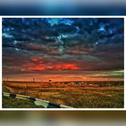 Scenic view of field against cloudy sky