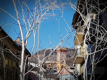 Bare tree in abandoned building against clear sky