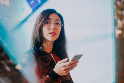 Young woman using mobile phone outdoors