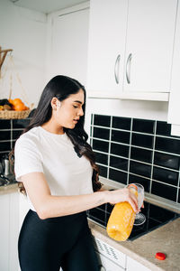 Young woman preparing food on table at home