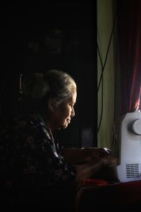 Side view of senior woman sitting at home