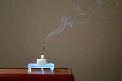 Close-up of lamp over table against white background