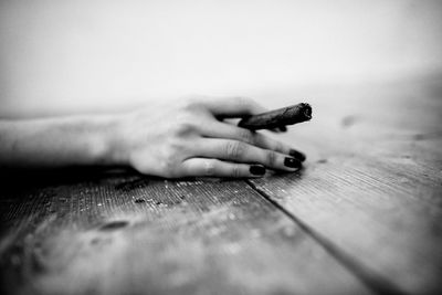 Close-up of female hand holding cigar