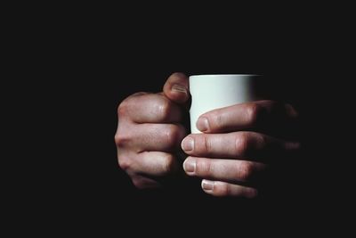 Cropped image of hand holding over black background