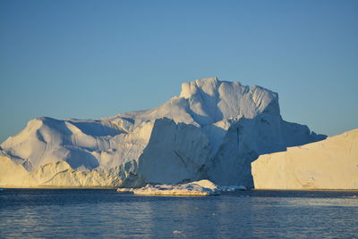 View of majestic iceberg in sea against sky