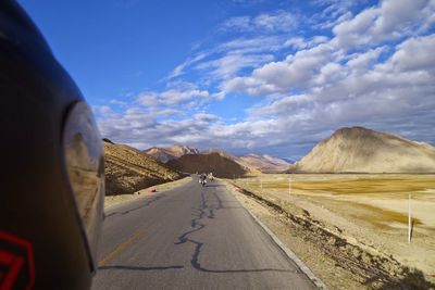 Road amidst landscape against sky seen through car windshield