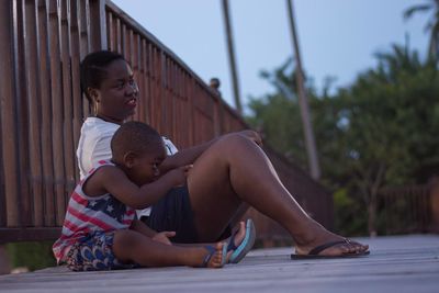 Mother sitting with son by railing