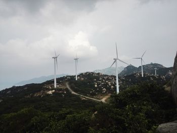 Traditional windmill on landscape against sky