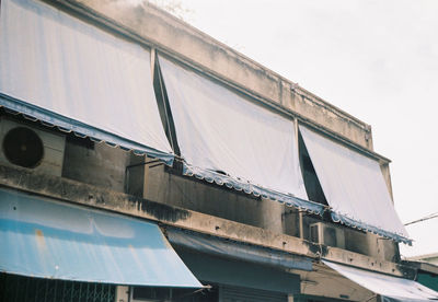 Low angle view of awnings on building against clear sky