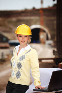 Portrait of female engineer using laptop at construction site