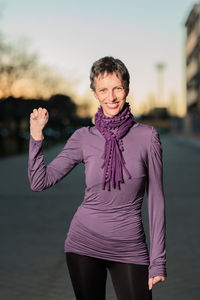 Portrait of smiling woman gesturing on road