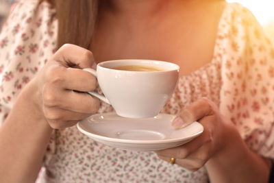 Midsection of woman holding coffee cup