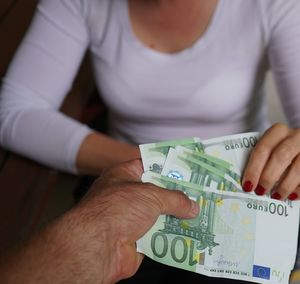 Midsection of businesswoman receiving money from man