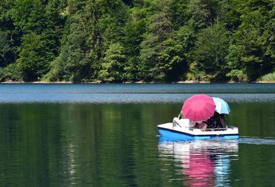 Person in boat on lake against trees