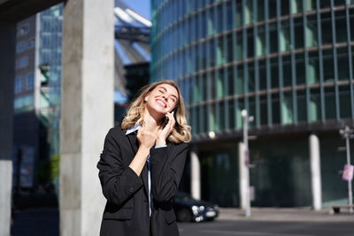 Businesswoman talking on mobile phone in city