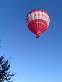 Low angle view of airplane flying against clear blue sky