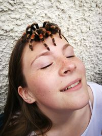 Close-up of spider on head of teenage girl