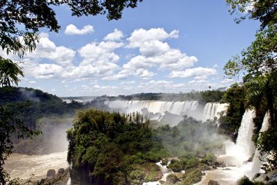 Scenic view of waterfall against sky