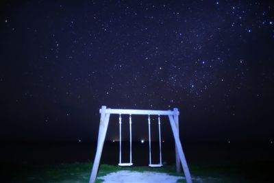 Lifeguard hut on land against sky at night