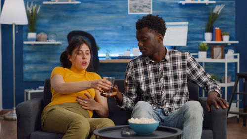 Young couple looking at while sitting on seat