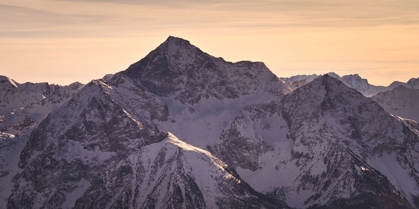Scenic view of snowcapped mountains against sky during sunset