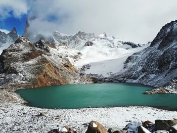 Scenic view of lake and snowcapped mountains against sky