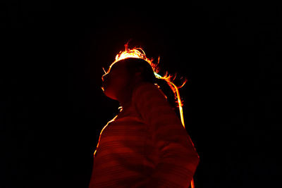 Low angle view of woman standing against sky at night