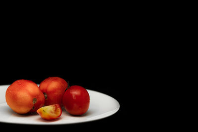 Close-up of apples in plate against black background