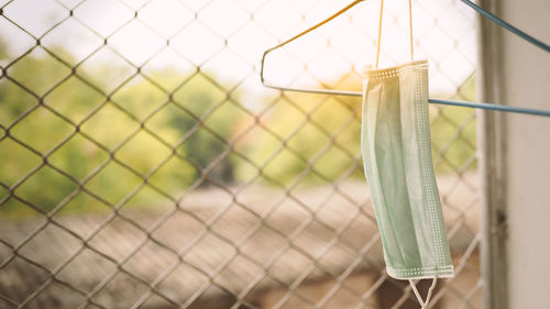 Close-up of clothespins hanging on chainlink fence