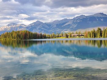 Scenic view of lake by mountains against sky