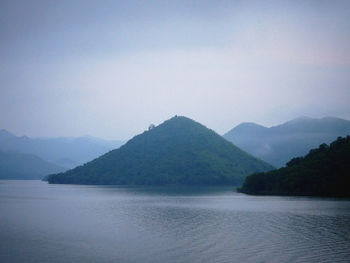 Scenic view of sea and mountains against sky