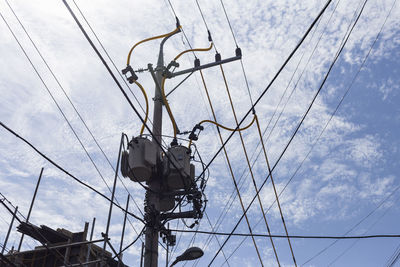 Low angle view of electricity pylon against sky