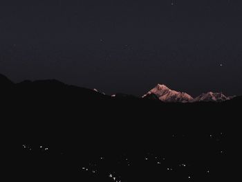 Scenic view of silhouette mountains against clear sky at night