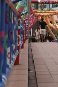 Rear view of people walking on footpath